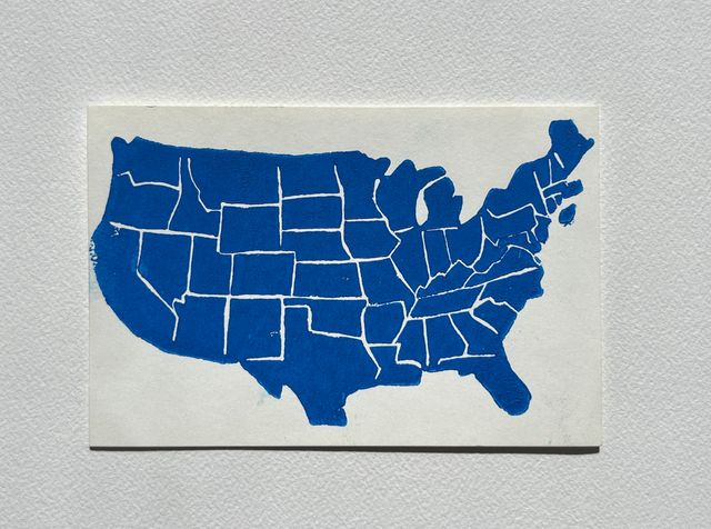 Postcard-sized linocut of the continental United States printed in bright blue, with white carved lines between the states.